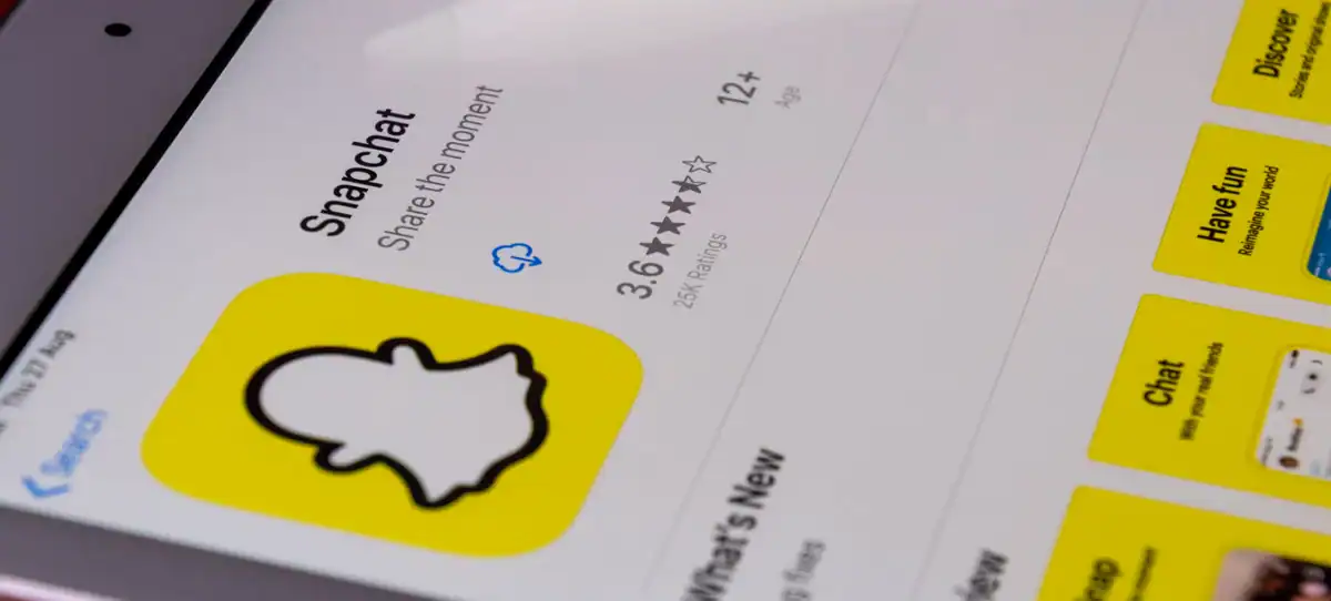 Fiche de l'application Snapchat sur un téléphone avec le logo fantôme jaune, la note de 3,6 étoiles et l'âge minimum de 12 ans.