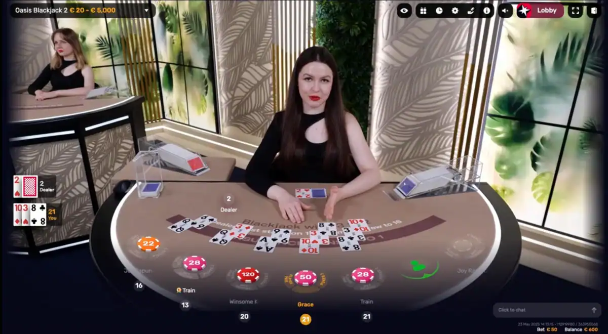 Capture d’écran d’une table de blackjack en direct « Oasis Blackjack 2 » avec une croupière assise face aux joueurs, cartes visibles sur le tapis, jetons de mises affichés et interface de jeu immersive, telle qu’on peut la retrouver dans la section casino en direct de Betory Casino.
