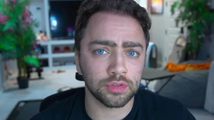 Mizkif en gros plan face caméra, regard sérieux, assis devant son setup de streaming, image issue d’un live Twitch après les polémiques.