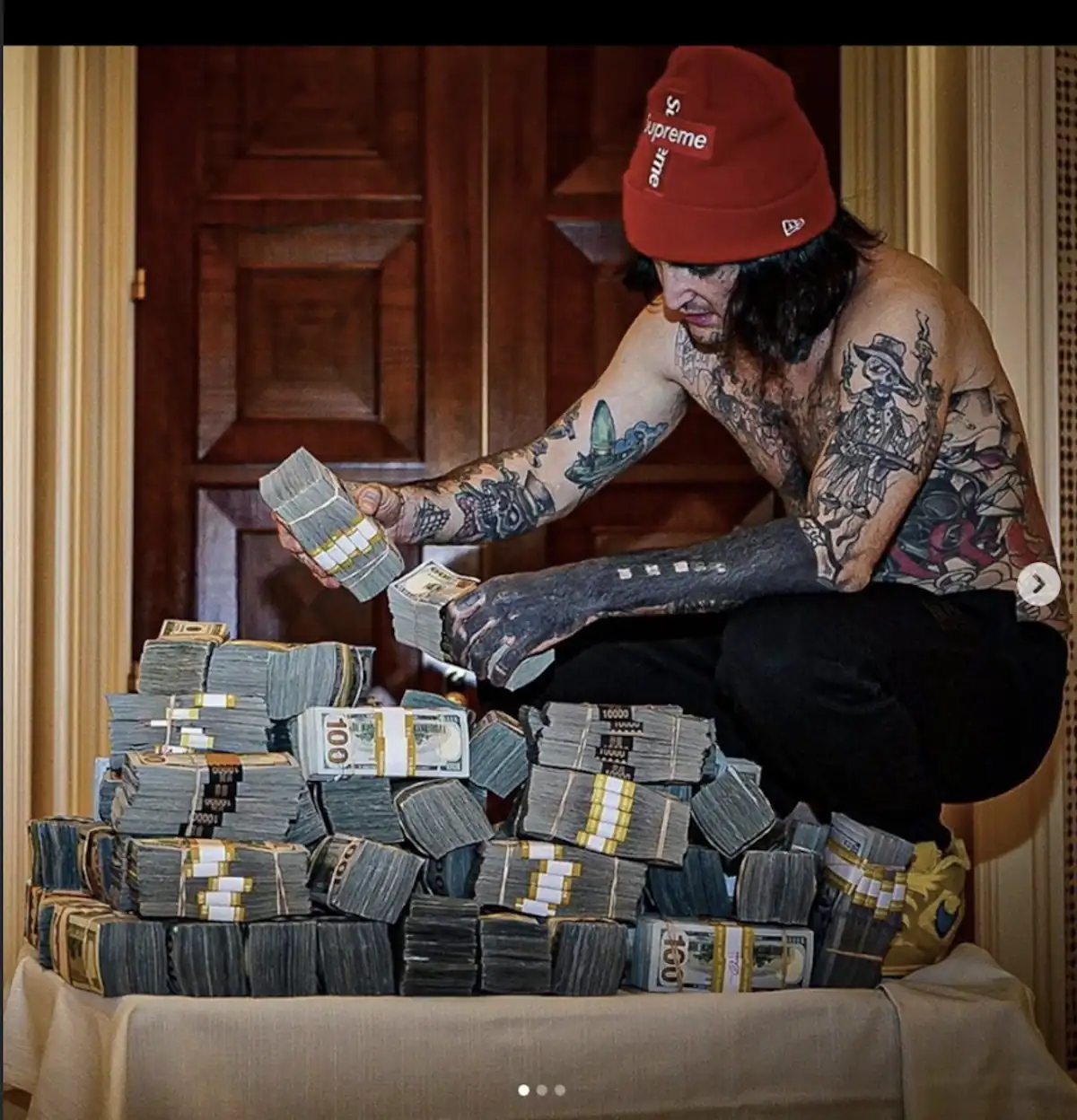 Mikki Mase assis devant des piles de billets en dollars, image mise en scène illustrant ses prétendus gains massifs au casino.