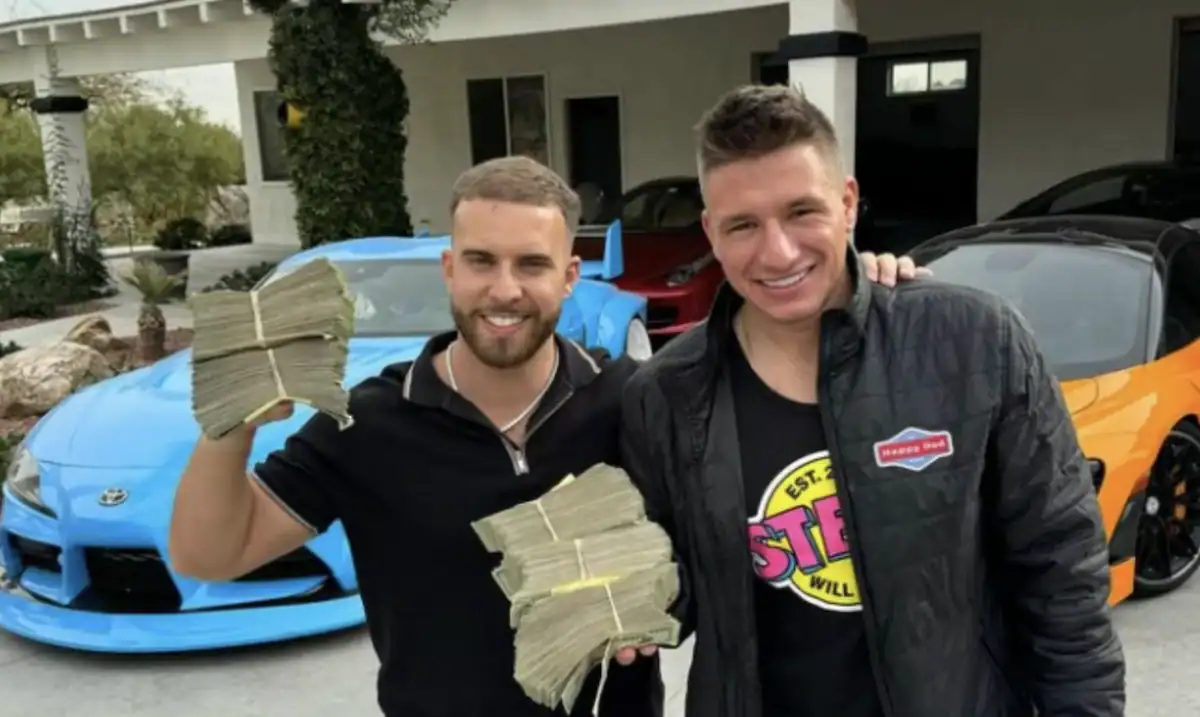 SteveWillDoIt posant avec un proche devant des voitures de luxe, tenant des liasses de billets en cash, image illustrant son lifestyle et son univers casino en ligne.